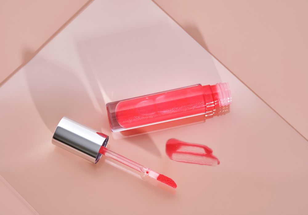 Tube de gloss rose brillant avec applicateur, illustration du gloss à la framboise fait maison.