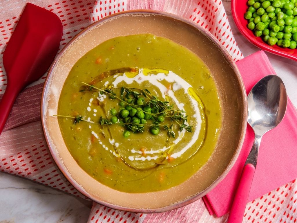 Bol de soupe de pois cassés verts avec herbes fraîches en topping