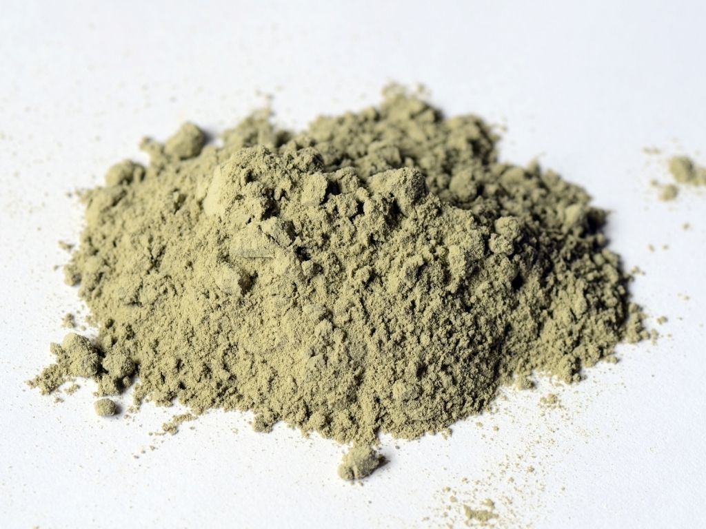 Tas de poudre d'argile verte surfine sur fond blanc