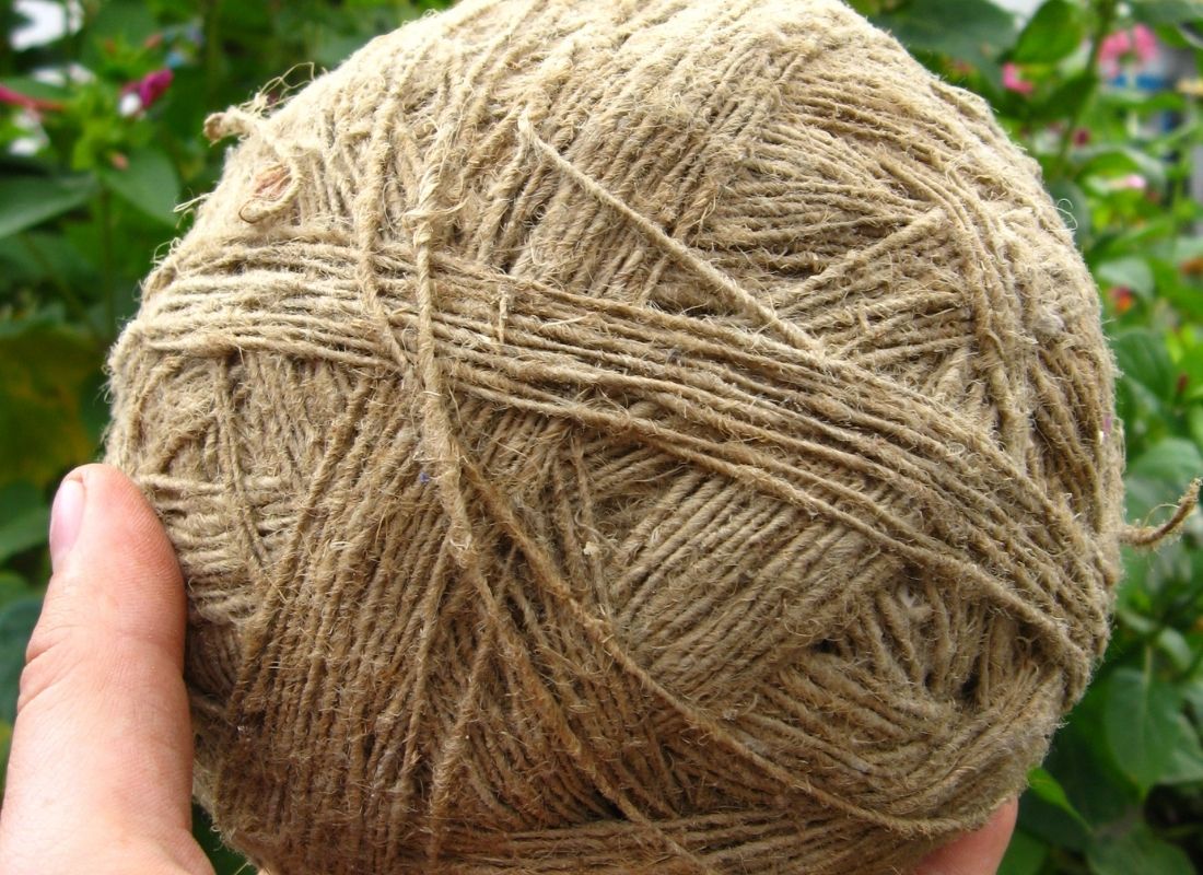 Pelote de fil en fibre naturelle filée à la main tenue dans une main